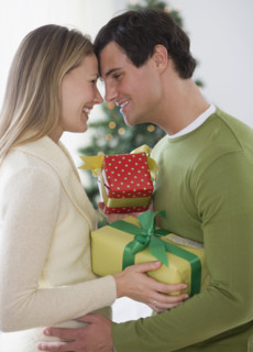 Couple with gifts hugging.