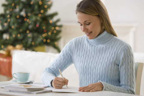 Woman writing at desk.