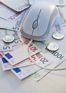 Computer mouse on euro banknotes and coins.