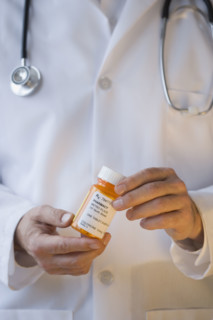 Doctor holding prescription bottle.