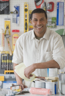 African sales clerk behind counter at hardware store.