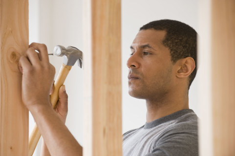 African man hammering nail.
