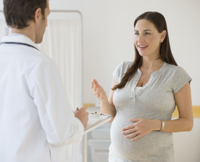 Pregnant woman talking to doctor.