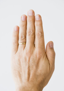 Close up of man’s hand wearing wedding ring.