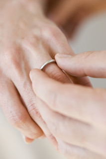 Man putting wedding ring on woman’s finger.