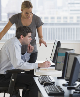 Businesspeople looking at computer.