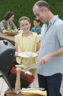 Family with two children barbecuing.