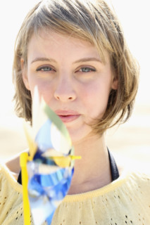 Woman blowing on pinwheel. Date : 2008