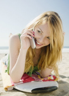 Woman talking on cell phone at beach. Date : 2008