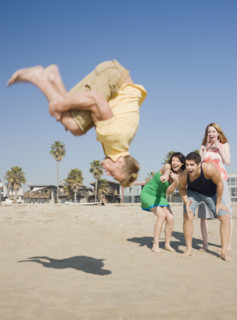 Man doing back flip on beach. Date : 2008