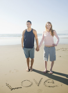 Couple next to Love written in sand. Date : 2008