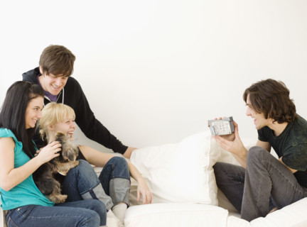 Man video recording friends on sofa. Date : 2008