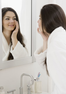 Woman applying face cream. Date : 2008