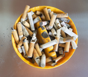 ashtray filled with many cigarette butts. Date : 2008