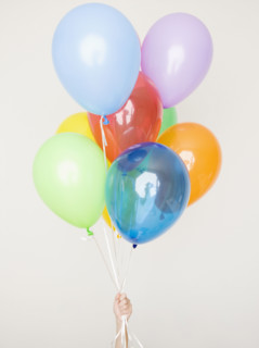 Child holding assorted balloons. Date : 2008