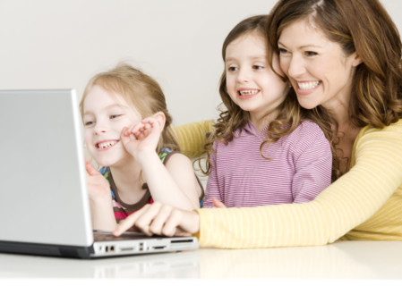 Mother and daughters looking at laptop. Date : 2008
