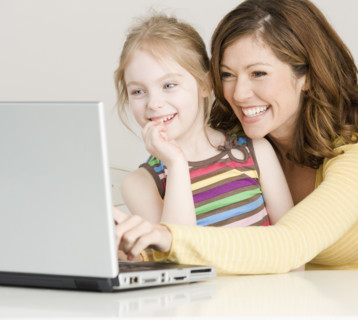 Mother and daughter looking at laptop. Date : 2008