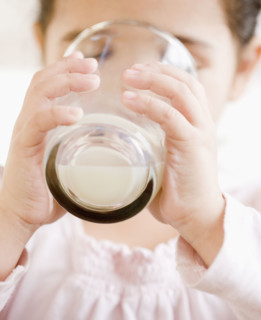 Hispanic girl drinking glass of milk. Date : 2008