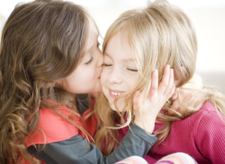 Girl kissing sister on cheek. Date : 2008