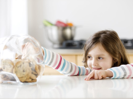 Girl reaching into cookie jar. Date : 2008
