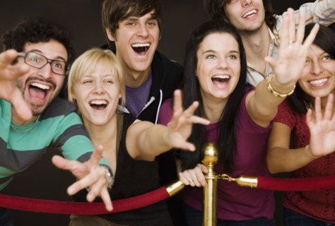 Group of people reaching across velvet rope. Date : 2008