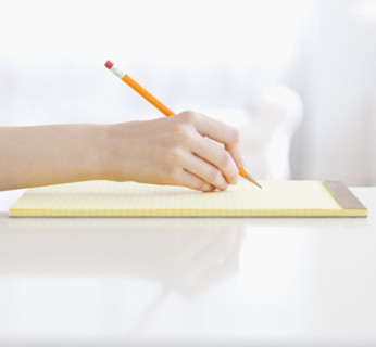 Woman writing on notepad. Date : 2008