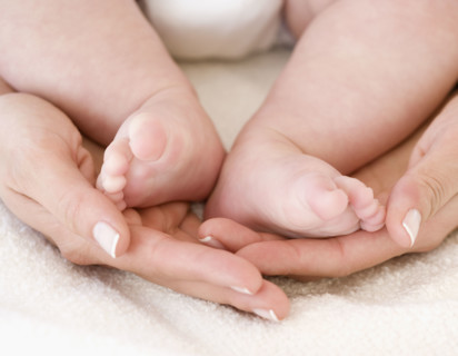 Close up of mother’s hands and baby’s feet. Date : 2008
