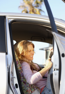 Woman sitting in car with door open. Date : 2008