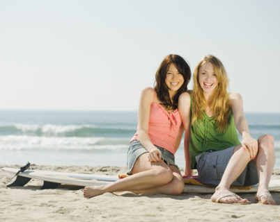 Multi-ethnic women sitting on surf board. Date : 2008