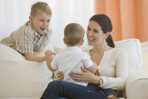 Mother and son smiling at baby.
