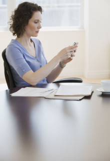 Businesswoman looking at electronic organizer.