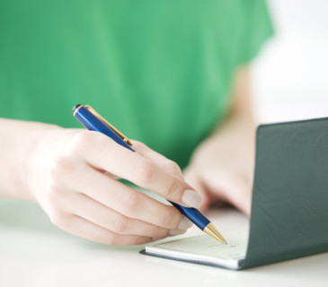 Close up of woman writing check. Date : 2008