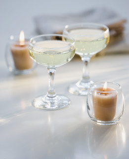 Glasses of champagne next to candles.