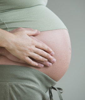 Couple’s hands on pregnant belly.