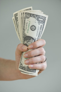 Woman holding handful of money.