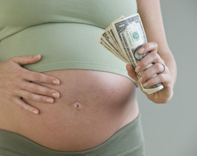 Pregnant woman holding money.