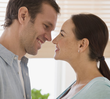 Hispanic couple smiling at each other.