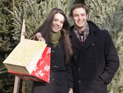 Couple with shopping bags in front of Christmas trees. Date : 2008