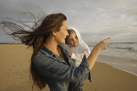 Mother holding baby at beach. Date : 2008