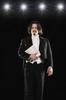 Man in tuxedo holding sheet music. Date : 2008