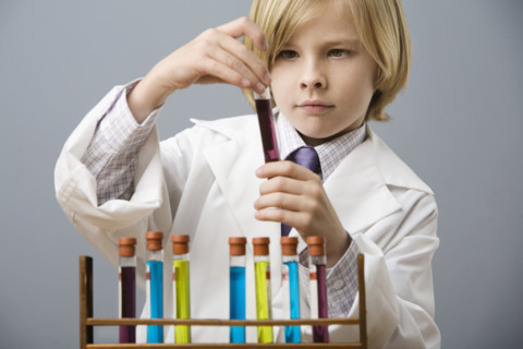 Boy looking at vial of liquid. Date : 2008