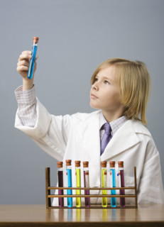 Boy looking at vial of liquid. Date : 2008