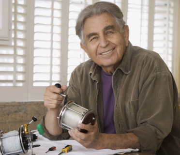 Senior man holding fishing reel. Date : 2008