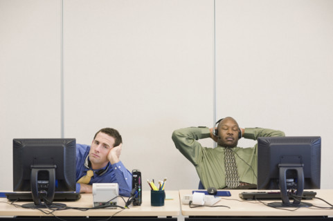 Multi-ethnic businessmen sitting at desks. Date : 2008