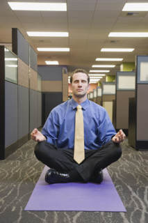 Businessman meditating in office. Date : 2008