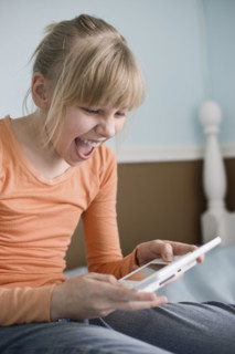 Girl playing handheld video game. Date : 2008