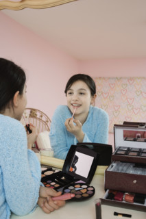 Girl applying lip gloss. Date : 2008
