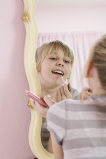 Girl applying lip gloss. Date : 2008