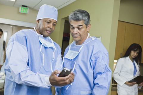 Multi-ethnic doctors looking at equipment. Date : 2008