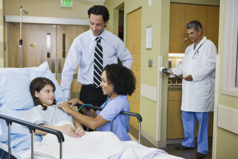 Girl in hospital gurney with father and nurse. Date : 2008